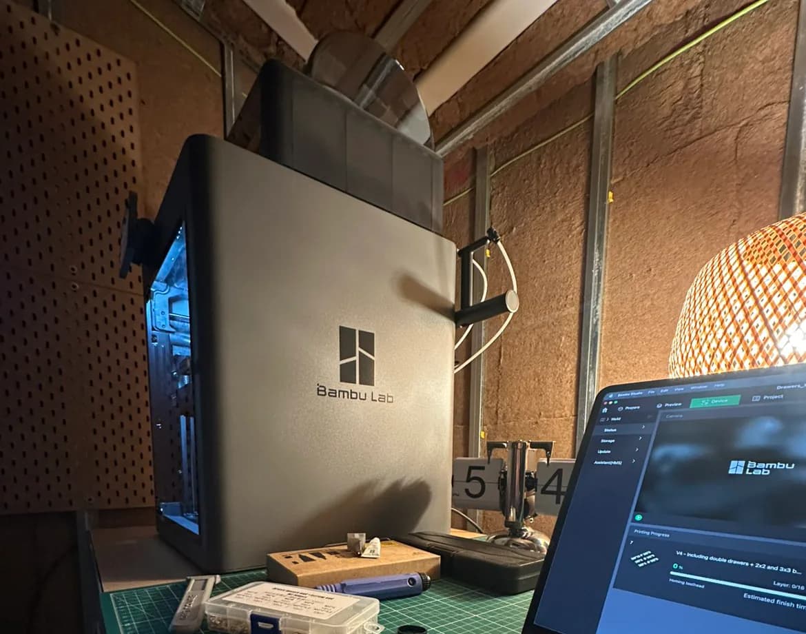 Imprimante 3D à filament de l'atelier, à côté de l'ordinateur où le logiciel prépare l'impression